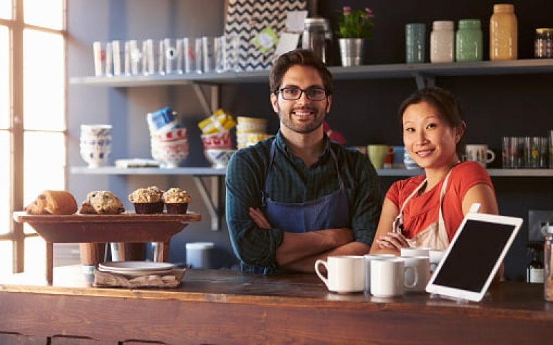 Portrait Of Couple Running Coffee Shop Behind Counter